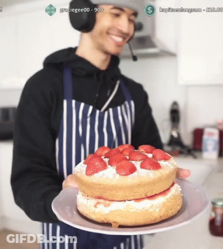Man In Apron Holding Strawberry Cake GIF
