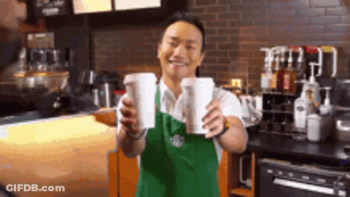 Man In Apron Holding Two Cups Of Coffee GIF