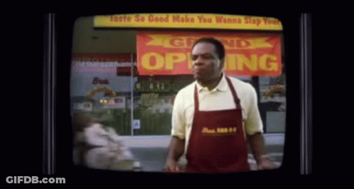 Man In Apron In Front Of Open Store GIF
