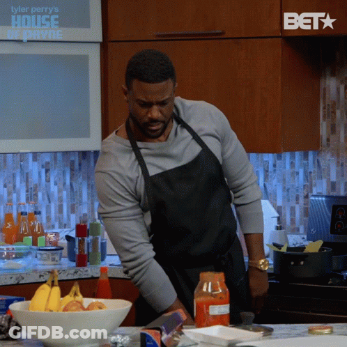 Man In Apron Preparing Food With BET Logo In Background GIF