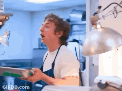 Man In Apron Standing In Kitchen GIF