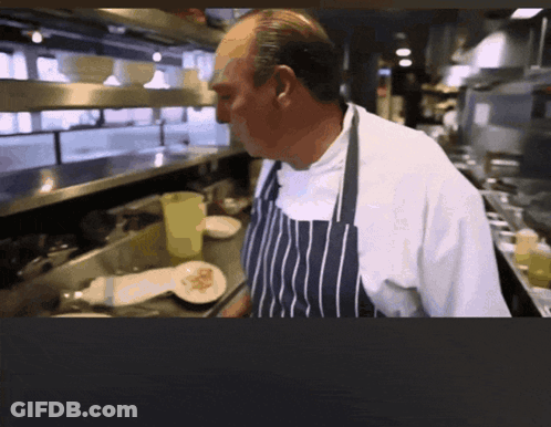 Man In Apron Standing In Kitchen GIF