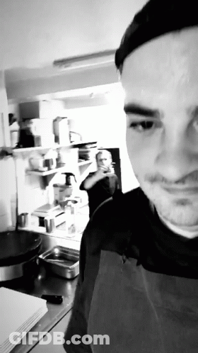 Man In Apron Taking Selfie In Kitchen GIF
