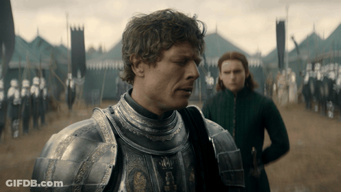 Man In Armor In Field With Woman Behind GIF
