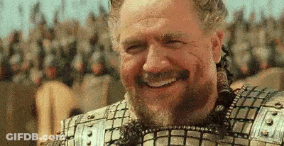 Man In Armor Smiling Before Soldiers GIF
