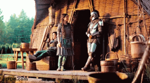 Man In Armor Standing Next To Woman On Bench GIF