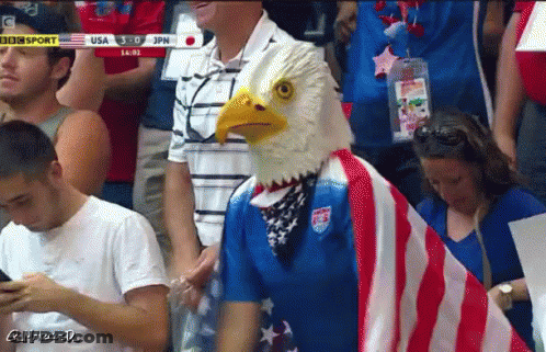 Man In Bald Eagle Mask Stands In Crowd GIF