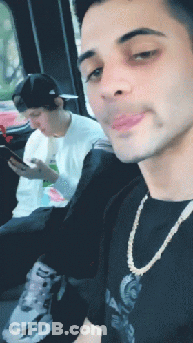 Man In Balenciaga Shirt Looking At Phone GIF