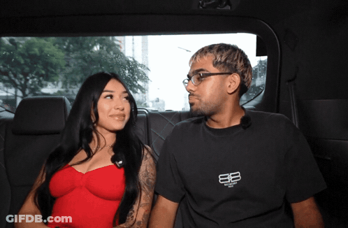 Man In Balenciaga Shirt Next To Woman In Red Top GIF