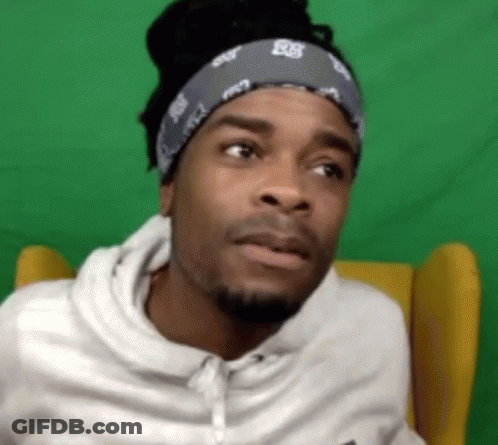 Man In Bandana And White Hoodie Sitting Before Green Screen GIF