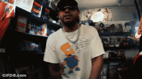 Man In Bart Simpson Shirt With Toy Shelf GIF