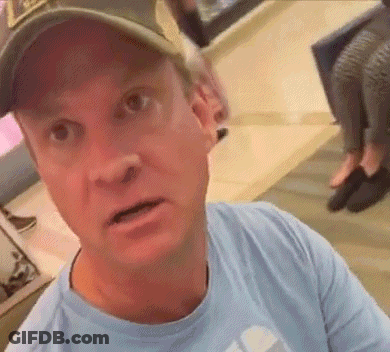 Man In Baseball Cap And Blue Shirt Looking At Camera GIF