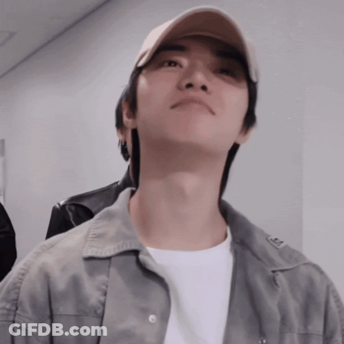Man In Baseball Cap And Grey Jacket Looks Up GIF
