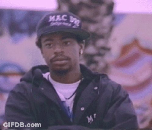 Man In Baseball Cap And Jacket Standing In Front Of Wall GIF