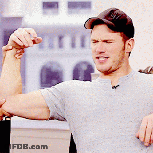 Man In Baseball Cap Flexing Muscles GIF