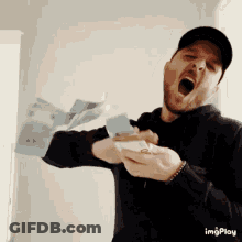 Man In Baseball Cap Holding Stack Of Money GIF