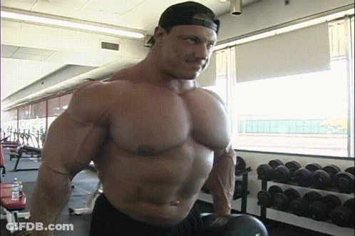 Man In Baseball Cap Lifting Weights In Gym GIF