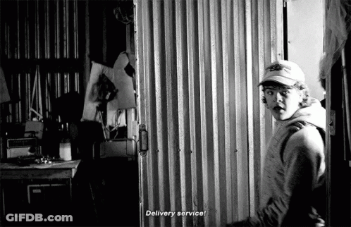 Man In Baseball Cap Standing In Front Of Door GIF