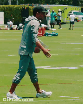 Man In Baseball Cap Walking On Football Field GIF