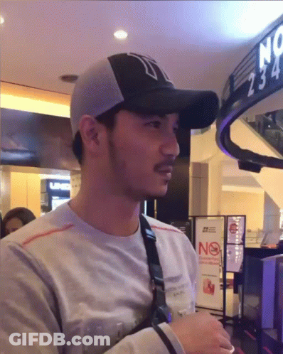 Man In Baseball Cap With N In Front Of No Smoking Sign GIF