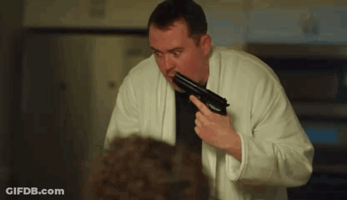 Man In Bathrobe Holding Gun GIF