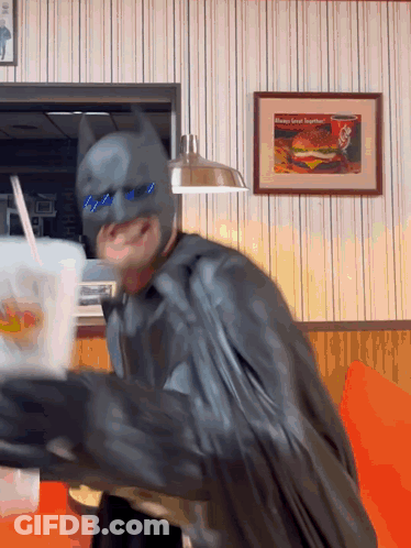 Man In Batman Costume Holding Drink GIF