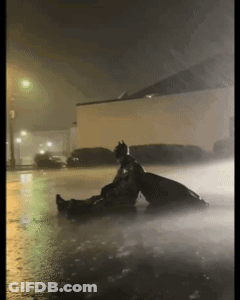 Man In Batman Costume Sitting In Rain GIF