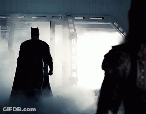 Man In Batman Costume Standing In Room With Smoke GIF