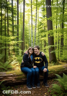 Man In Batman Shirt Sits Next To Woman In Forest GIF