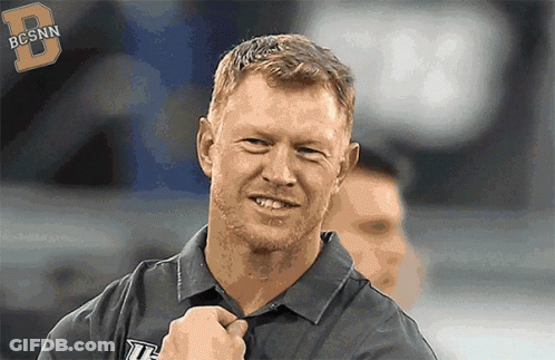 Man In Bcsnn Shirt Smiling At Camera GIF