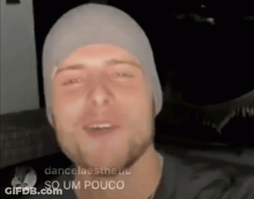 Man In Beanie And Black Shirt Smiling And Talking GIF