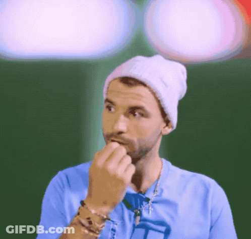Man In Beanie And Blue Shirt Biting Finger GIF
