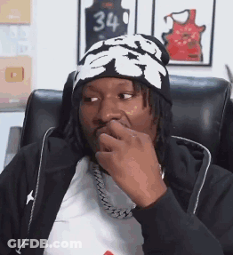 Man In Beanie And Chain With Hand On Mouth GIF