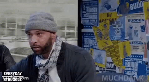 Man In Beanie And Scarf In Front Of Posters GIF