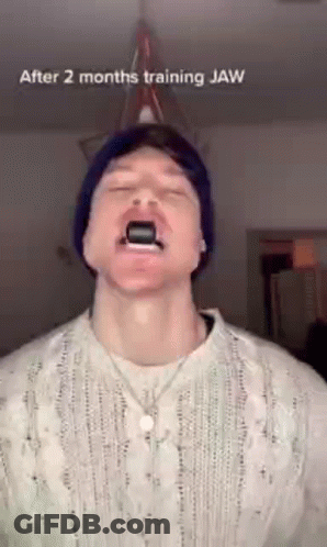 Man In Beanie And Sweater Using Jaw Trainer GIF