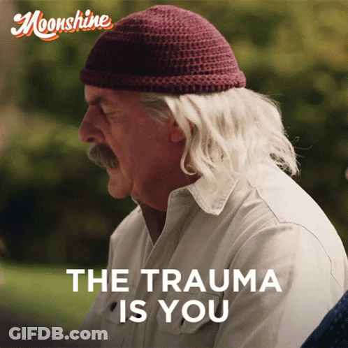 Man In Beanie And White Shirt Saying The Trauma Is You GIF