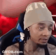 Man In Beanie Sitting And Looking At Camera GIF
