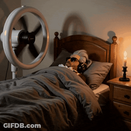 Man In Bed With Headphones Fan And Candle GIF