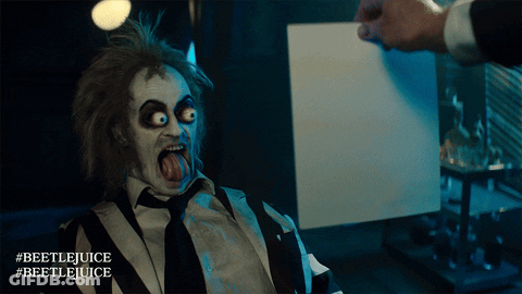 Man In Beetlejuice Costume Holding Paper GIF