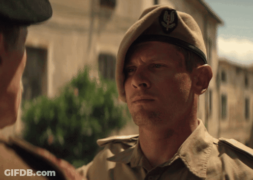 Man In Beret With Leaf Looking At Another Man GIF