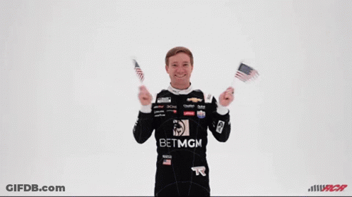 Man In Betmgm Shirt Holding Two American Flags GIF