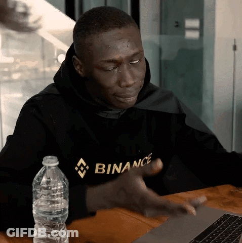 Man In Binance Hoodie Sitting At Table GIF