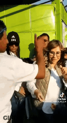 Man In Black Adidas Hat Thumbs Up To Woman In Glasses GIF