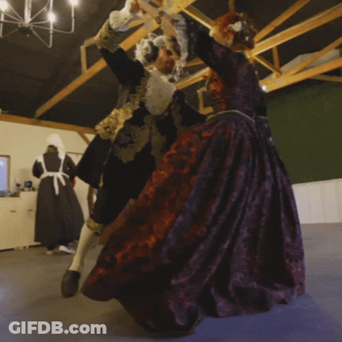 Man In Black And Gold Dancing With Woman In Purple GIF
