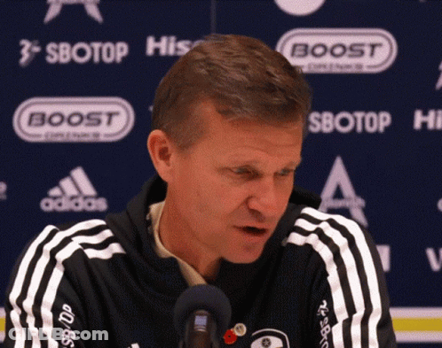 Man In Black And White Adidas Jacket In Front Of Boost Sign GIF