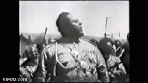 Man In Black And White Facing Armed Crowd GIF