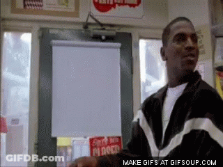 Man In Black And White Jacket In Front Of Mr Roco Sign GIF