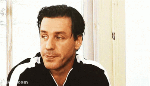 Man In Black And White Striped Shirt Looking At Camera GIF