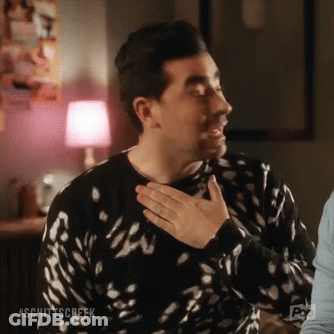 Man In Black And White Sweater Holding Hands To Chest GIF