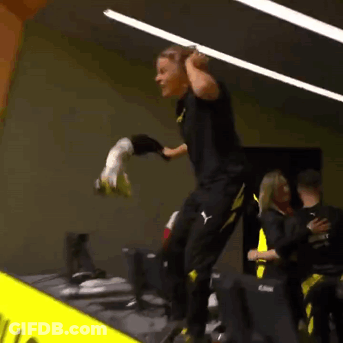 Man In Black And Yellow Puma Outfit Jumping While Holding Soccer Ball GIF